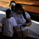 Black mother and son in front of school bus